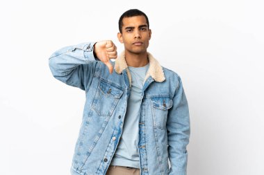 İzole edilmiş beyaz arka plan üzerinde Afro-Amerikalı bir adam olumsuz ifade ile baş parmağını aşağı gösteriyor
