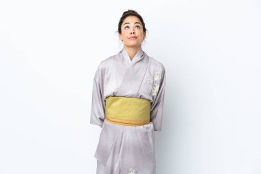Woman wearing kimono over isolated background and looking up