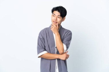 Beyaz arka planda izole edilmiş genç bir Çinli yan bakıp gülümsüyor.