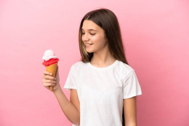 Kornet dondurması ile izole edilmiş pembe arka plan görünümlü küçük kız.