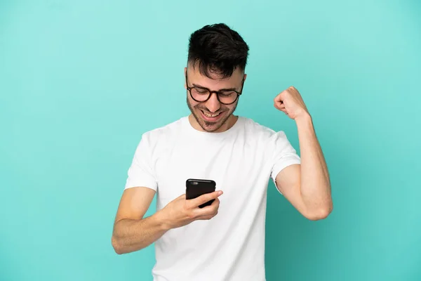 Genç Beyaz Adam Mavi Arka Planda Izole Edilmiş Cep Telefonu — Stok fotoğraf