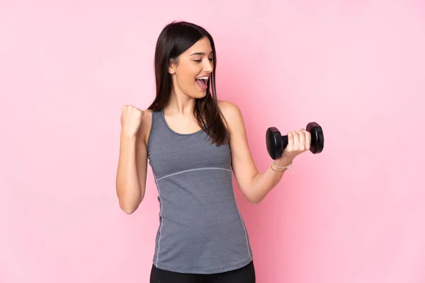 stock image Young woman making weightlifting isolated on pink background celebrating a victory