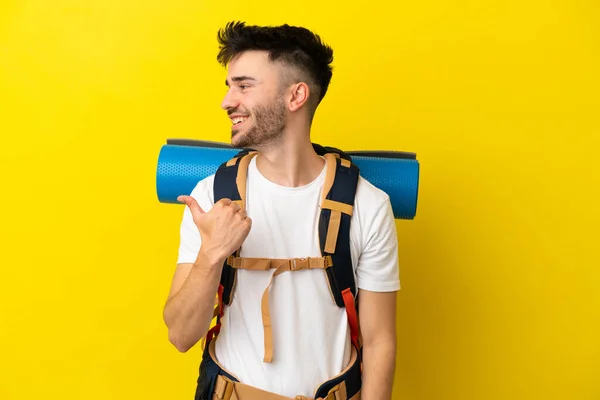 Jovem Montanhista Caucasiano Com Uma Grande Mochila Isolada Fundo Amarelo — Fotografia de Stock