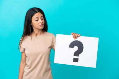 İzole edilmiş arka plan üzerinde soru işareti olan bir pankart tutan genç bir kadın.