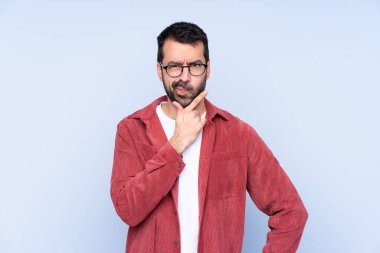 Young caucasian man wearing corduroy jacket over blue background thinking