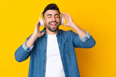 Sarı arka plan üzerinde beyaz bir adam müzik dinliyor ve şarkı söylüyor.