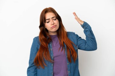 Genç kızıl saçlı kadın beyaz arka planda izole edilmiş, yorgun ve hasta bir ifadeyle.