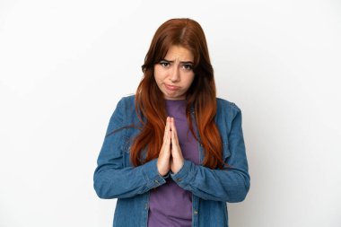 Beyaz arka planda izole edilmiş genç kızıl saçlı kadın avuç içlerini bir arada tutuyor. İnsan bir şey ister.