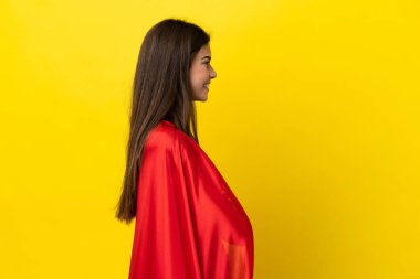 Super Hero Brazilian woman isolated on yellow background in lateral position