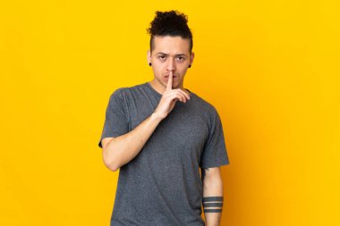 İzole edilmiş arka planda beyaz bir adam sessizlik işareti gösteriyor. Parmağını ağzına sok.