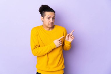 İzole edilmiş arka plandaki beyaz adam korkmuş ve kenarı işaret ediyor.