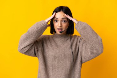 Sarı arka planda, sürpriz bir ifadeyle izole edilmiş genç bir pazarlamacı kadın.