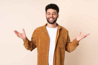 Bej arka planda izole edilmiş genç Faslı adam çok gülümsüyor.