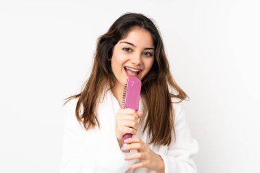 Beyaz arka planda saçları taranmış ve şarkı söyleyen beyaz tenli bir kadın.