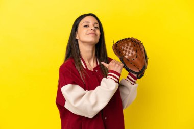 Beyzbol oynayan beyaz bir kadın sarı arka planda soyutlanmış gururlu ve kendini beğenmiş.