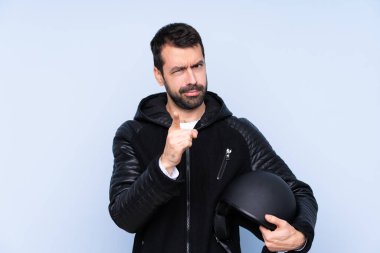 Man with a motorcycle helmet over isolated background frustrated and pointing to the front