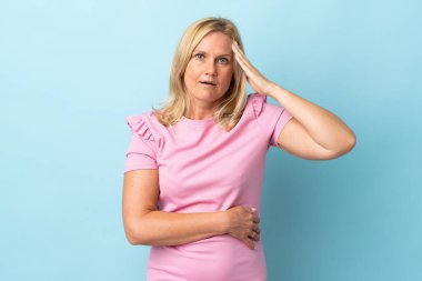 Mavi arka planda izole edilmiş orta yaşlı kadın bir şey fark etti ve çözümü arıyor.