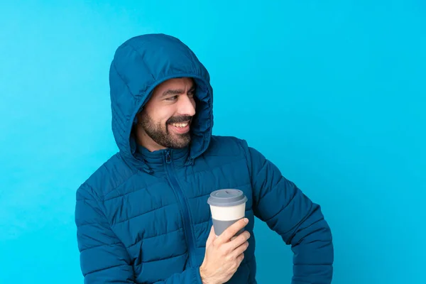 Man Wearing Winter Jacket Holding Takeaway Coffee Isolated Blue Background — Fotografia de Stock