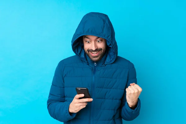 Man Wearing Winter Jacket Holding Takeaway Coffee Isolated Blue Background — Fotografia de Stock