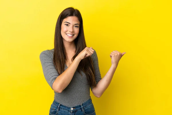 Jovem Brasileira Isolada Sobre Fundo Amarelo Apontando Para Lado Para — Fotografia de Stock