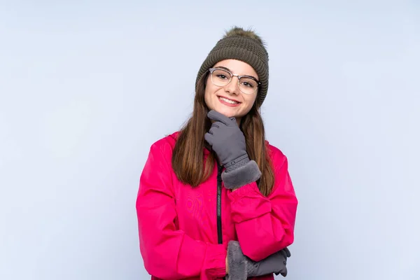 Young Girl Winter Hat Isolated Blue Background Glasses Smiling — Φωτογραφία Αρχείου