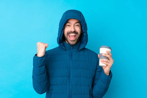 Man Wearing Winter Jacket Holding Takeaway Coffee Isolated Blue Background — Foto Stock