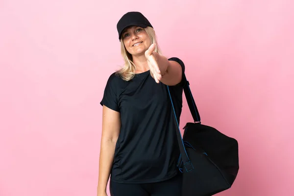 Middle Age Woman Sport Bag Isolated Pink Background Shaking Hands — Stock Fotó