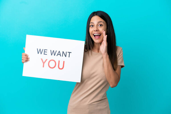 Young woman over isolated background holding We Want You board and shouting