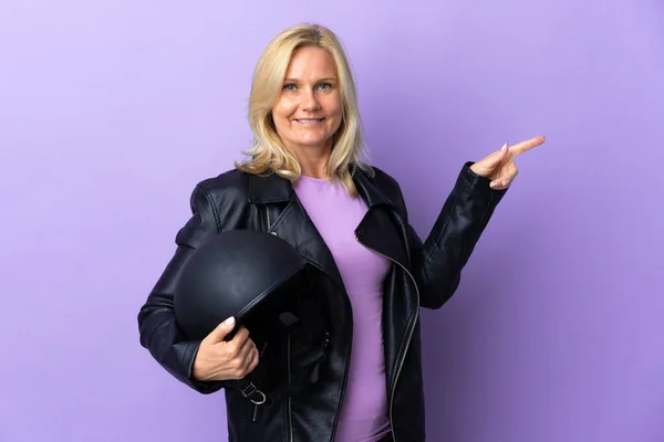 Middle Age Woman Holding Motorcycle Helmet Isolated Purple Background Pointing — Stock fotografie