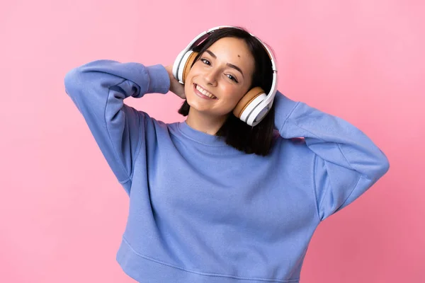 Joven Mujer Caucásica Aislada Sobre Fondo Rosa Escuchando Música —  Fotos de Stock