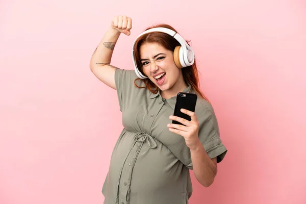 Young Redhead Caucasian Woman Isolated Pink Background Pregnant Listening Music — 스톡 사진