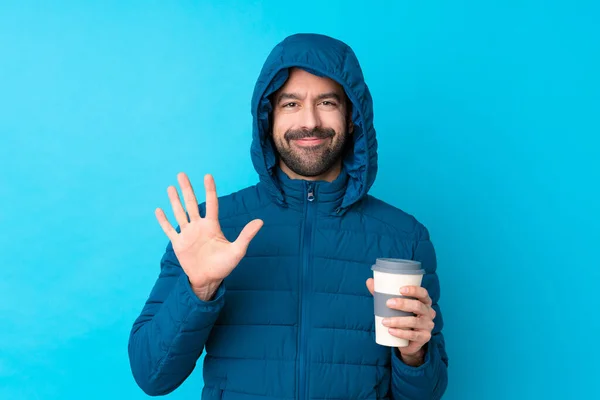 Man Wearing Winter Jacket Holding Takeaway Coffee Isolated Blue Background — Foto Stock