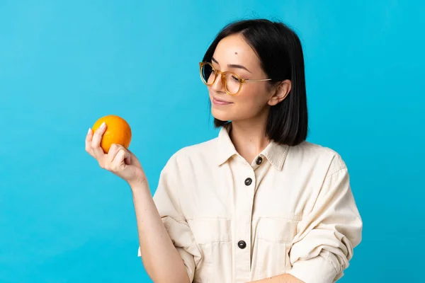 Ung Kaukasisk Kvinna Isolerad Blå Bakgrund Håller Orange — Stockfoto