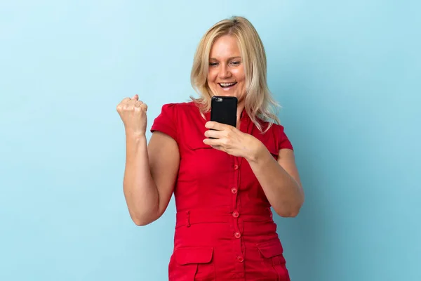Middle Age Woman Isolated Blue Background Phone Victory Position — Stockfoto
