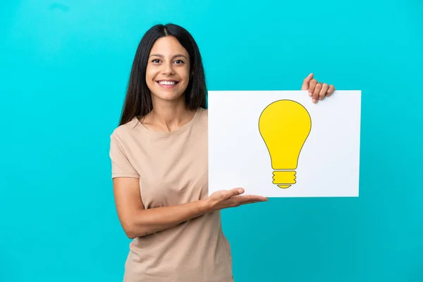 Young Woman Isolated Background Holding Placard Bulb Icon Happy Expression — Stock Photo, Image