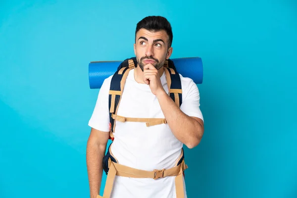 Joven Montañero Hombre Sobre Aislado Fondo Azul Mirando Hacia Arriba —  Fotos de Stock