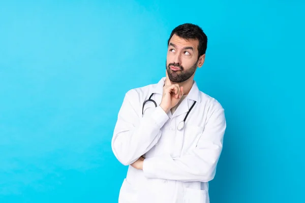 Young Caucasian Man Isolated Background Wearing Doctor Gown Thinking — Stockfoto