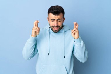 İzole edilmiş mavi arka planı olan beyaz bir adam.