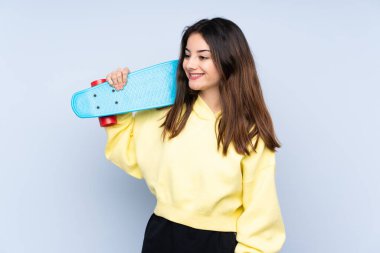 Mavi arka planda paten kayan beyaz bir kadın.