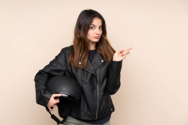 Motosiklet kasklı bir kadın bej arka planda izole edilmiş.