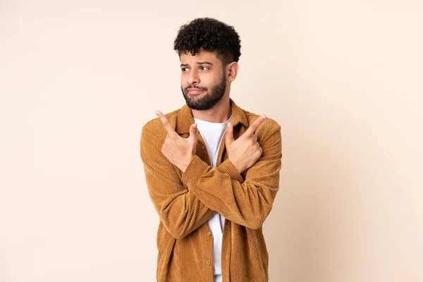 Young Moroccan Man Isolated Beige Background Pointing Laterals Having Doubts — Foto Stock