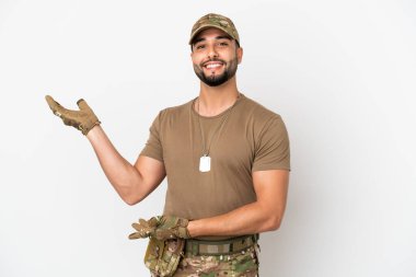 Genç Arap asker, beyaz arka planda izole edilmiş. Gelmesi için ellerini yana uzatıyor.