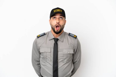 Genç Arap adam beyaz arka planda izole edilmiş yukarı bakıyor ve şaşırmış bir ifadeyle