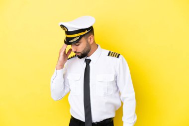 Arap uçak pilotu, sarı arka planda baş ağrısı ile izole edildi.