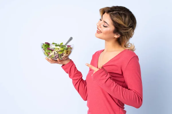 Mulher Adolescente Com Salada Isolada Fundo Azul Apontando — Fotografia de Stock