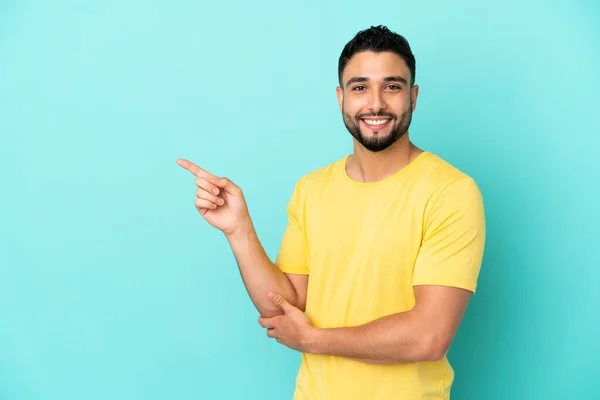 Junger Arabischer Mann Auf Blauem Hintergrund Isoliert Und Zeigt Mit — Stockfoto