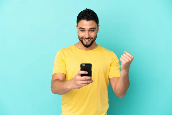 Joven Árabe Aislado Sobre Fondo Azul Sorprendido Enviando Mensaje —  Fotos de Stock