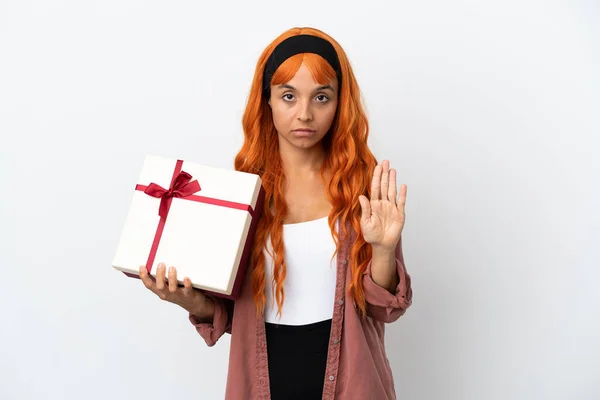 Молодая Женщина Оранжевыми Волосами Держит Подарок Белом Фоне Делая Остановку — стоковое фото