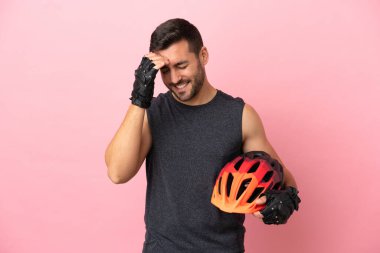 Genç bisikletçi, pembe arka planda izole edilmiş gülüyor.
