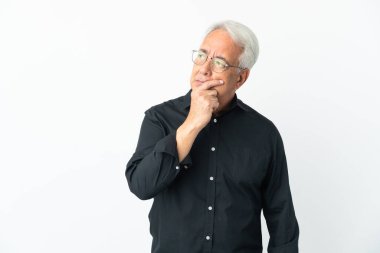 Beyaz arka planda izole edilmiş orta yaşlı Brezilyalı adamın şüpheleri ve kafa karıştırıcı yüz ifadesi var.